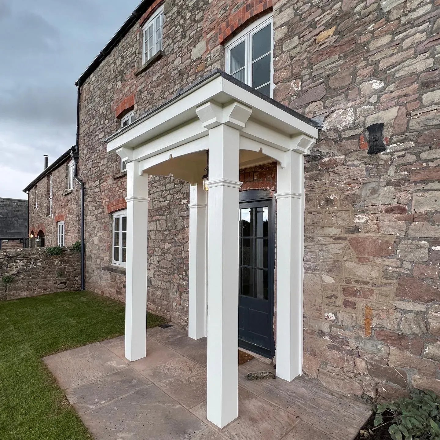 New portico with timber columns on a stone farmhouse