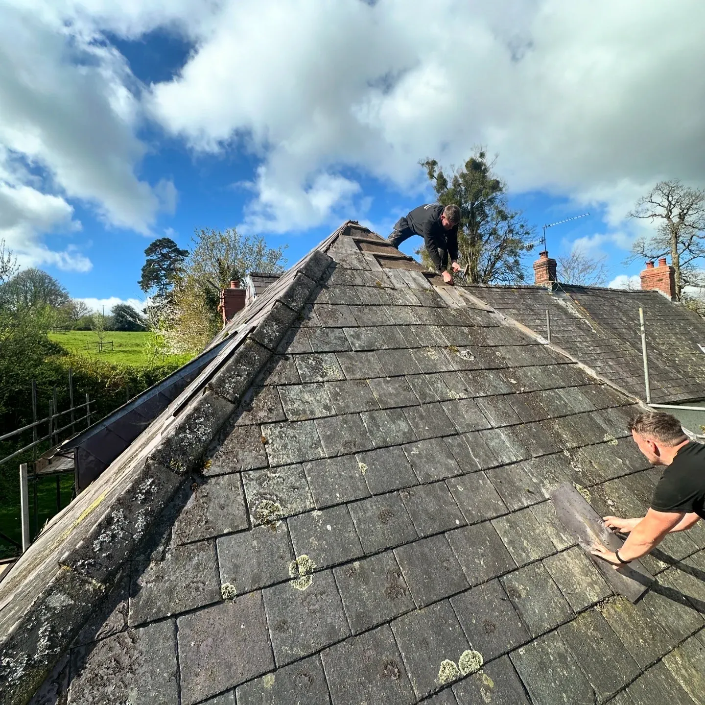 Roofers at work on a slate roof