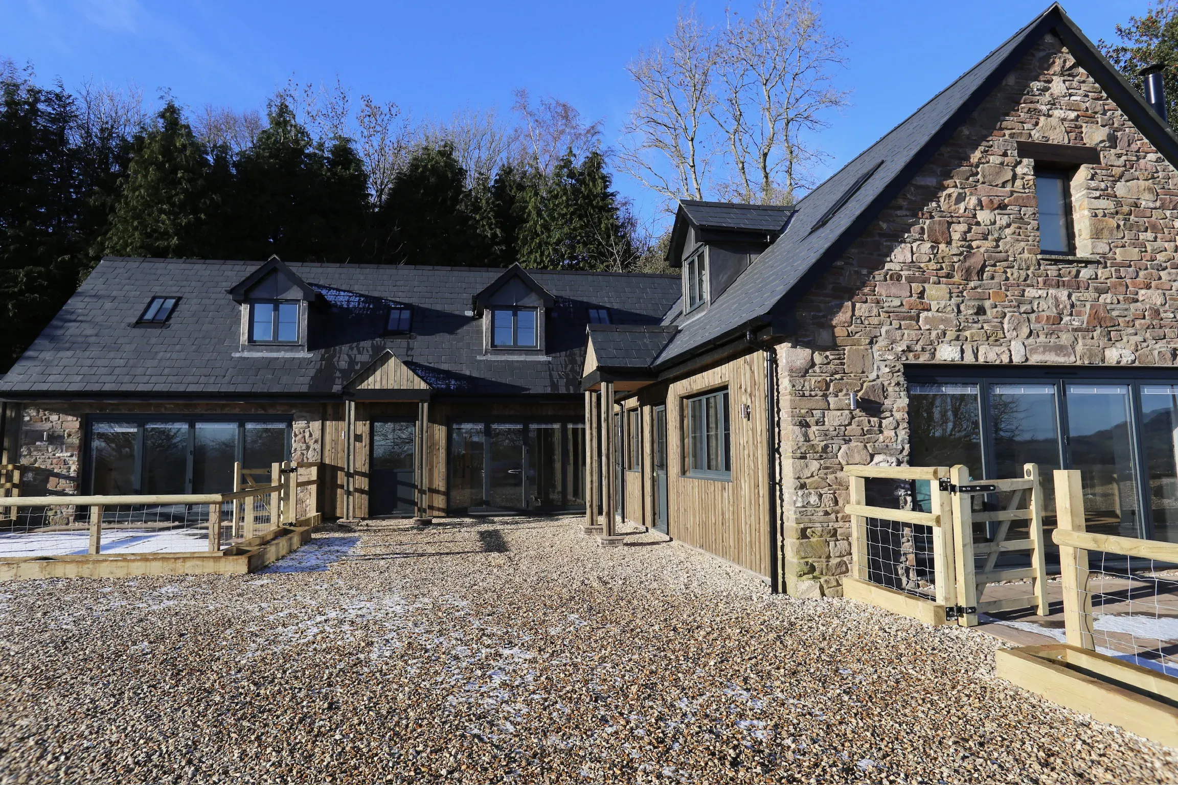New stone and timber house on a frosty morning, with a glazed gable