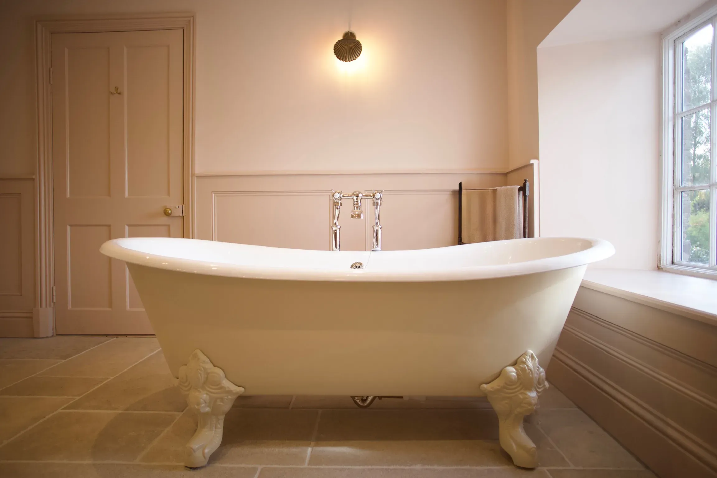 Cast iron roll-top bath in a panelled bathroom