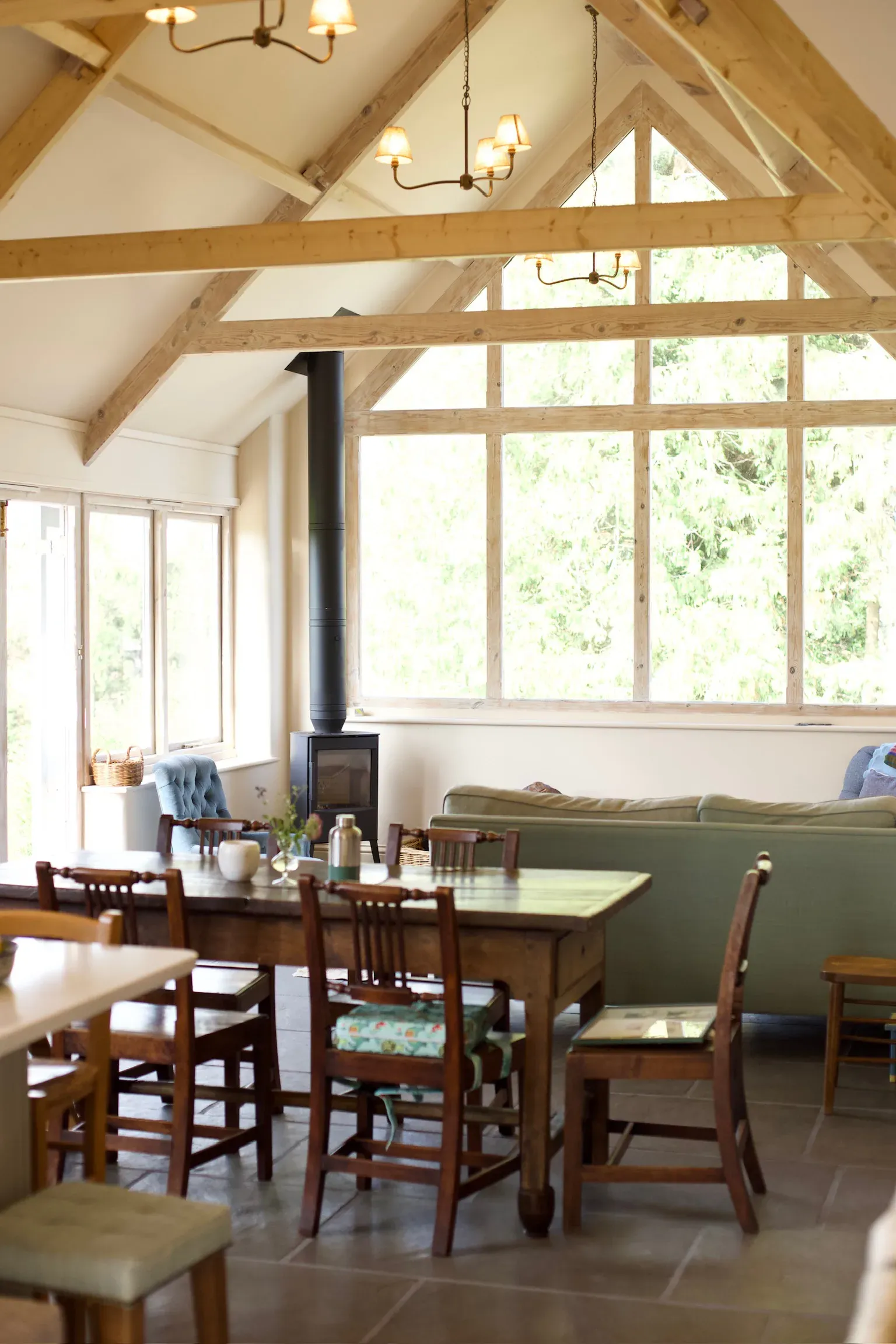 Finished oak frame garden room with a glazed gable, dining table and wood-burning stove