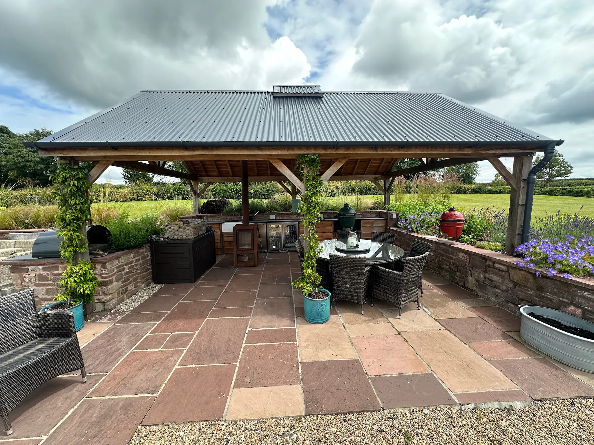 Oak frame garden pavilion with a dining table, seen from the garden