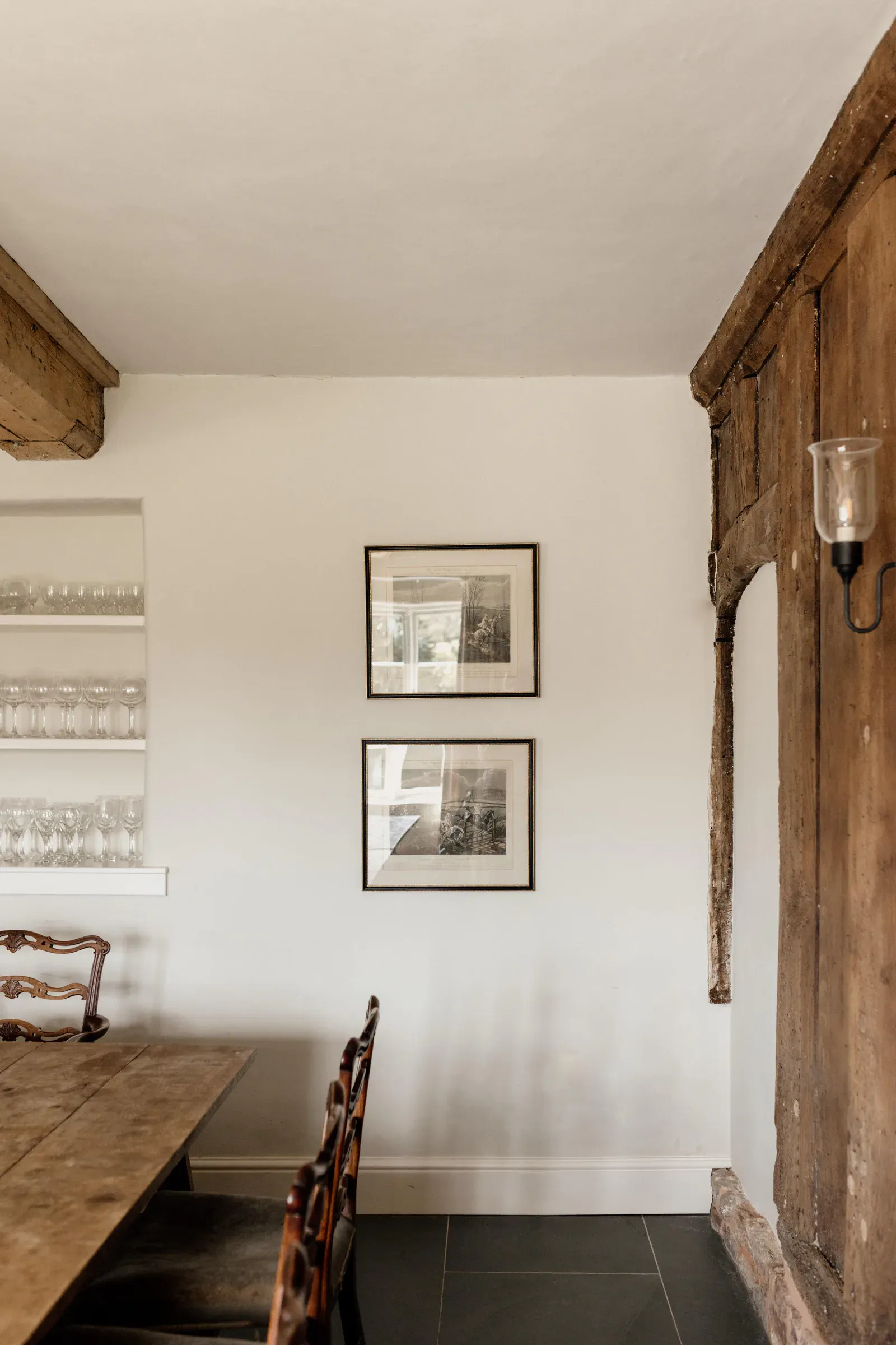Dining room with a long oak table and an exposed timber-framed wall