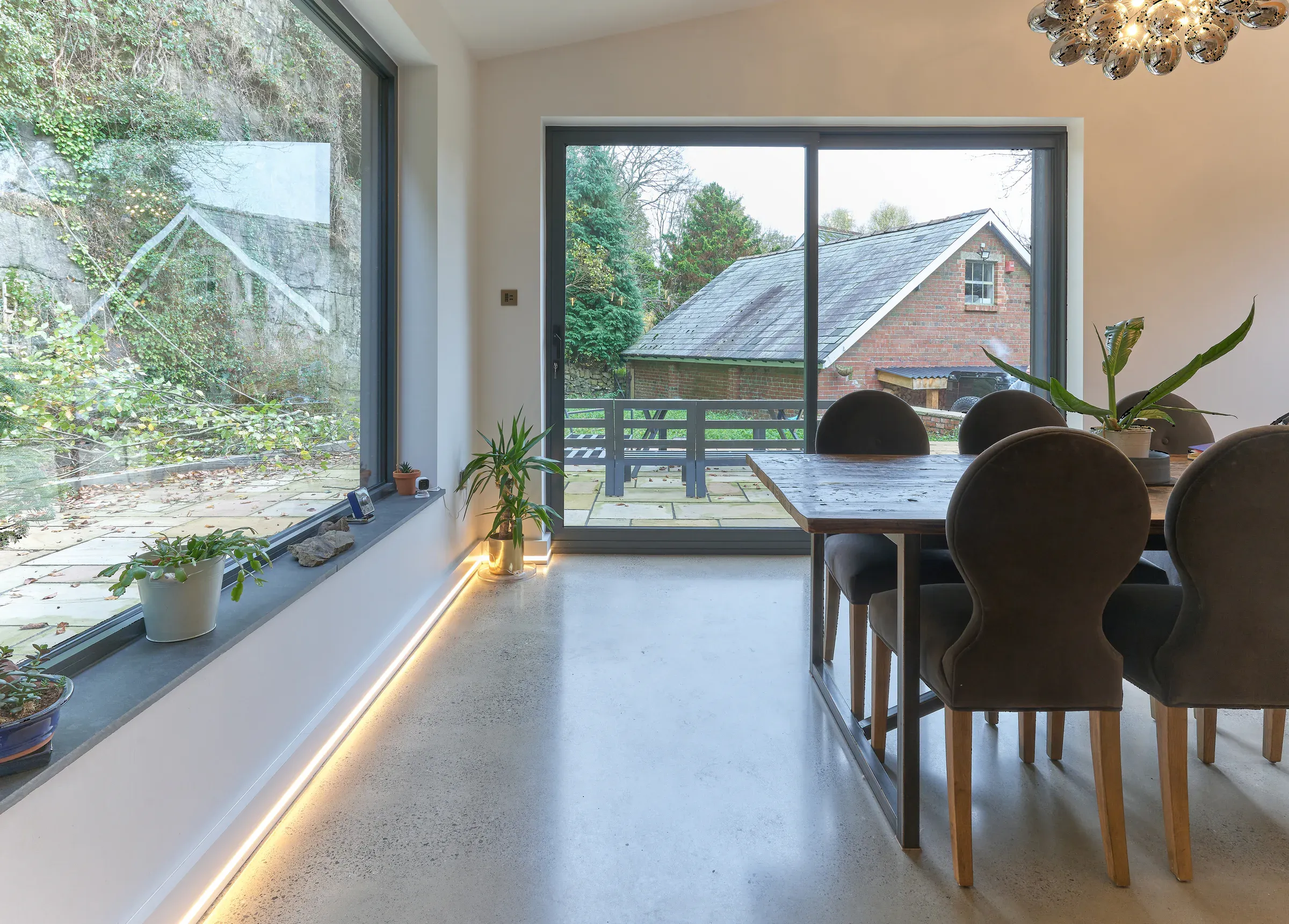 Dining table beside a full-height window, with the house's original gable seen outside