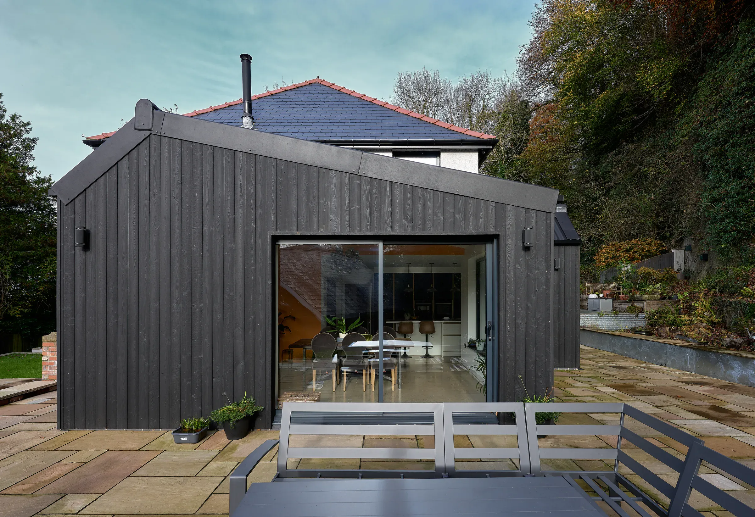 Glazed dining room extension with the terrace outside and trees beyond