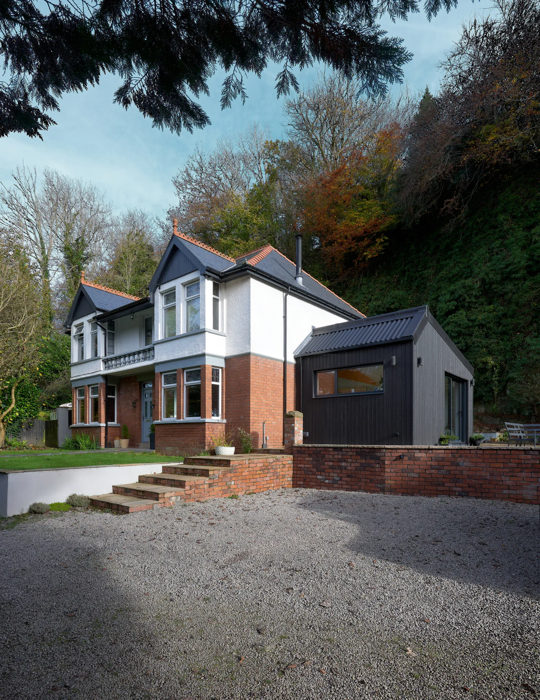 Rendered front elevation with the black extension and brick retaining wall