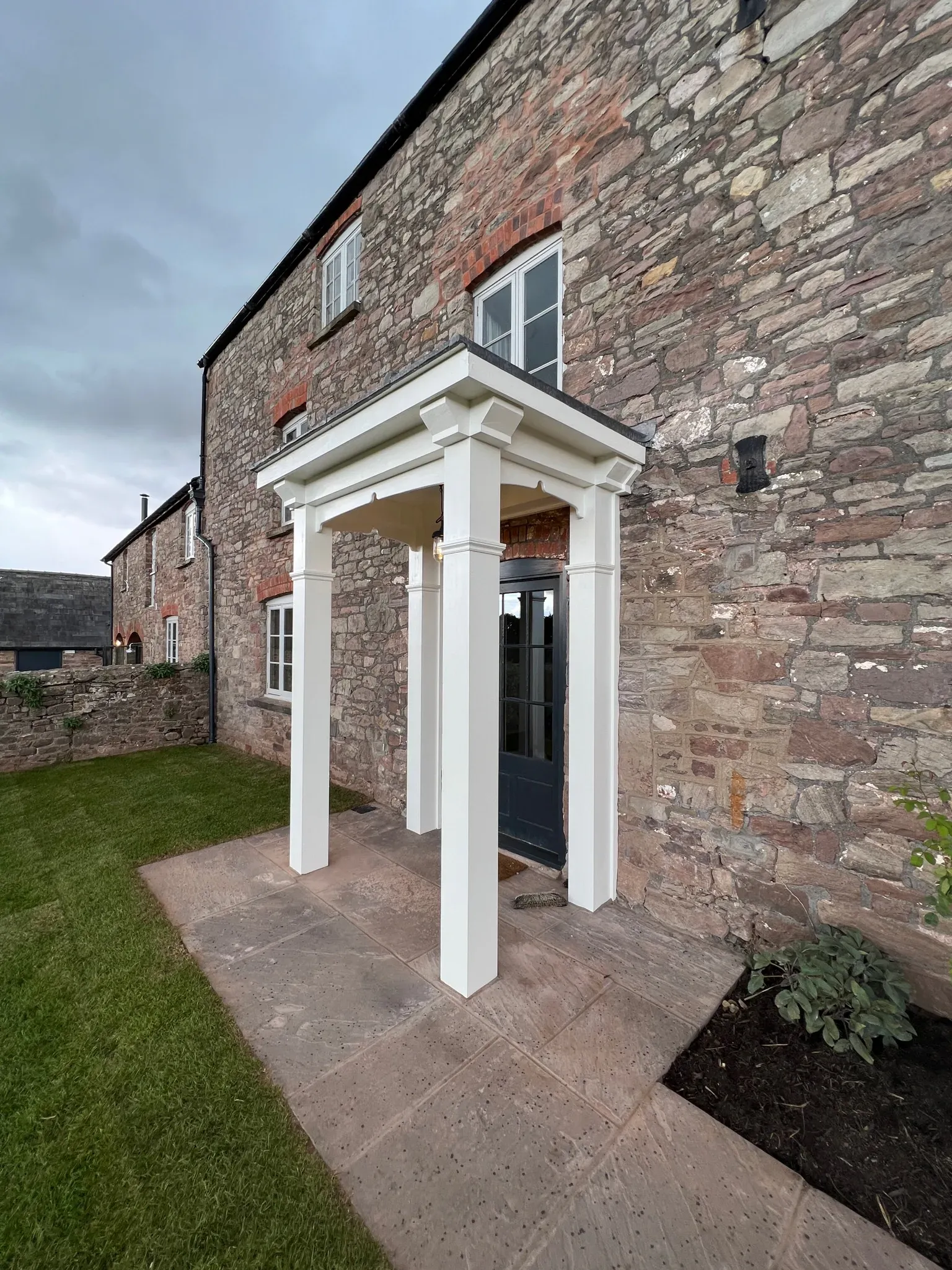 Stone elevation with a new white-painted portico over the front door