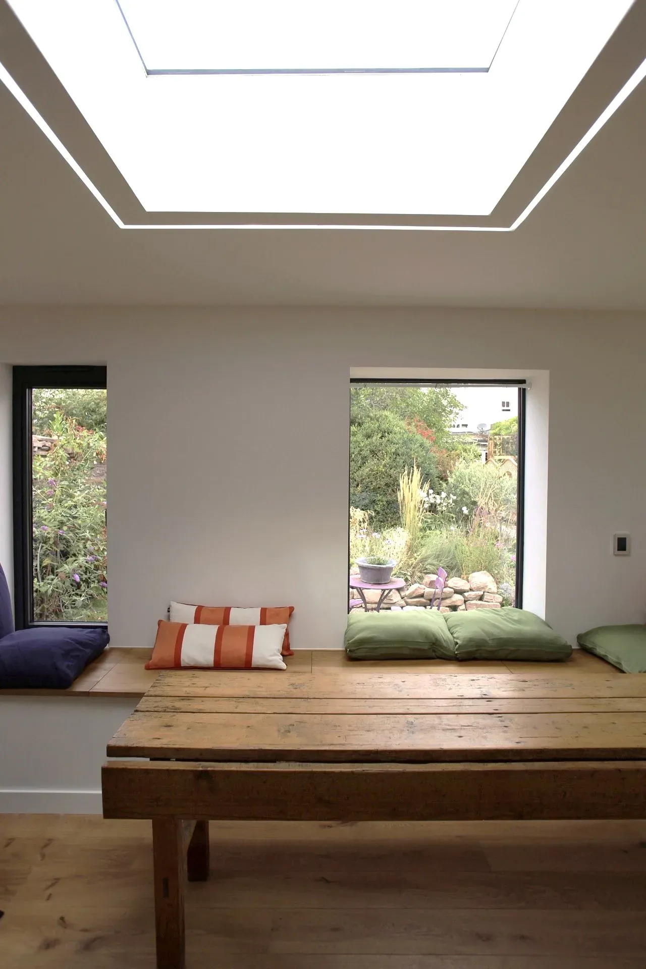 Built-in oak bench seat beneath the picture window, with an oak table