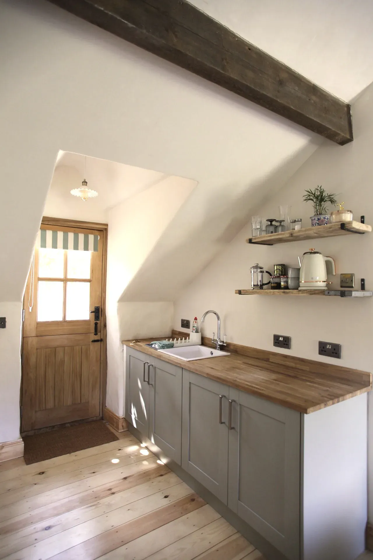 Kitchen looking towards the oak stable door, with light coming through the glazed top half