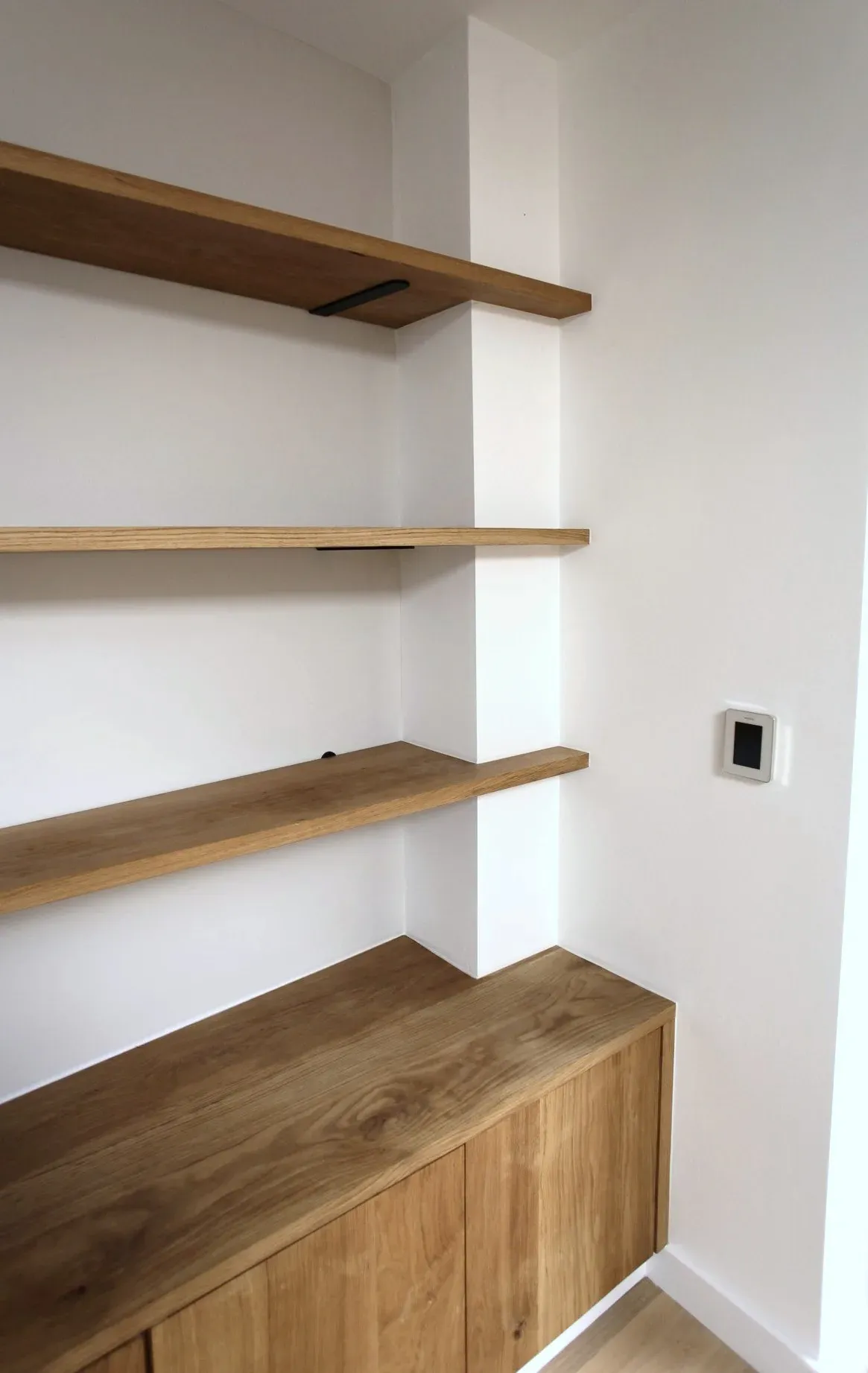Oak shelving and cupboard built into an alcove
